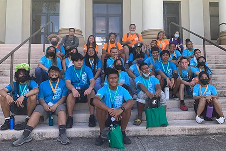 high school students taking a group photos at a college campus
